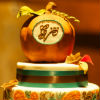 Harvest-themed two-tiered cake with ornate leaf detailing and apple topper